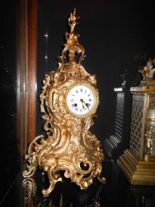 Orologio francese in stile barocco in bronzo dorato e patinato - metà Ottocento - Funzionante